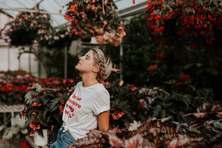 woman resting among flowers in deep state of thought