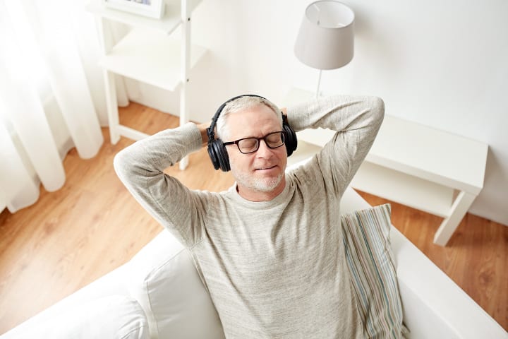 man listening to guided hypnosis on comfortable couch